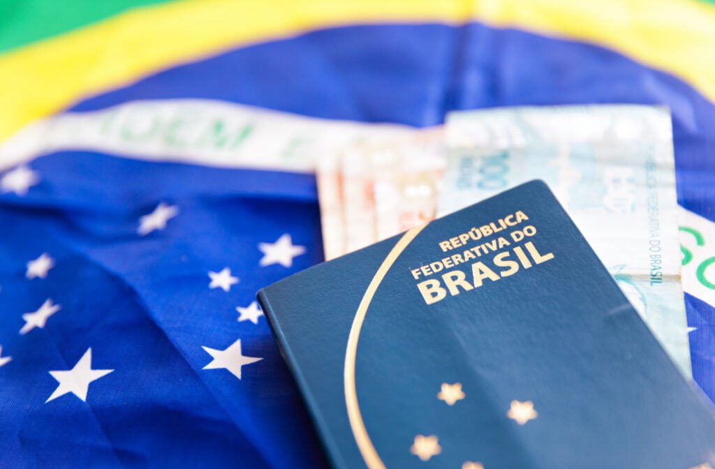 Passaporte brasileiro em cima da bandeira do Brasil